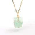 Detail macro view of a natural irregular green raw stone pendant with gold wire wrapping - Aventurine (Wire Wrapped) / Gold