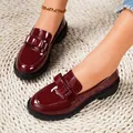 Detailed view of elegant burgundy patent leather loafers featuring a stylish bow. - 36 / Burgundy