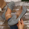 Detail shot of the grey faux-leather texture and tassel ornament on these chic women's loafers - Gray