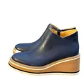 Side view of navy blue textured leather wedge ankle boots featuring a side zipper closure - 35 / Blue