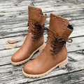 Detailed side view of brown mid-calf boots with studded collar and decorative laces. - 36 / Vintage Brown