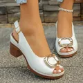 Elegant white chunky heel sandals featuring a decorative gold buckle and open toe patent finish - 36 / White