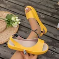 Detail view of yellow peep-toe flat sandals with elastic strap on wooden background - 36 / Yellow