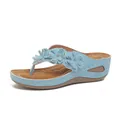 Vista lateral de chanclas con cuña azules con tres flores decorativas y costuras blancas - 36 / Azul cielo