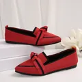 Close-up of red knitted pointed-toe flat shoes with elegant bow and black trim detail - 36 / Red
