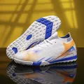 Witte en blauwe mid-top flyknit turf voetbalschoenen met opvallende oranje accenten - 36 / Turf Noppen (TF) / Wit