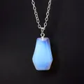 Detailed macro view of a translucent blue opalite coffin pendant with a silver chain - Opal