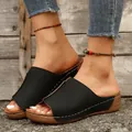 Detail shot of black peep-toe wedge mule sandals with contrast stitching on feet - 36 / Black