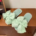 Detalle de pantuflas de felpa verde menta con un lazo de tela con volantes gigante - 36-37 / Verde