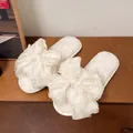 Vista detallada de las elegantes zapatillas blancas de felpa con un gran lazo decorativo de organza - 36-37 / Blanco