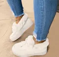 Detailed view of white plush-lined platform winter boots worn with denim jeans. - 35 / White