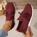 Detail view of burgundy fly-knit women's sneakers with lace-up design and white sole - 36 / Dark Red