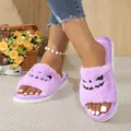 Close-up of purple fuzzy slippers featuring a black Halloween pumpkin face design. - 35-36 / Purple