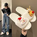 Detailed view of festive white plush slippers featuring Santa Claus and Reindeer cartoon motifs - 36 / Off White