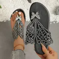 Detail view of black summer thong sandals with rhinestone butterfly and cutout wings - Black
