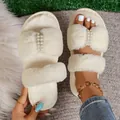 Detailed view of fuzzy slippers with elegant pearl and rhinestone embellishments. - 36-37 / White