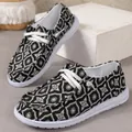 Close-up van zwart-witte canvas sneakers met een geometrisch patroon en witte veters - 36 / Geometrische Print (Zwart)