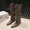 Detailed view of vintage brown knee-high cowboy boots with decorative metallic rivets - 35 / Brown
