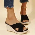Detailed macro view of black criss-cross suede straps on straw woven wedge platform sandals - 35 / Black