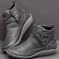 Detailed view of grey leather flat ankle boots with stylish button strap accents. - 35 / Gray