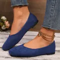 Detailed macro view of blue suede square-toe slip-on flat shoes with rustic wood background - Blue