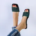 Close-up of green leopard print square toe flat slides worn with denim jeans. - 41 / Green