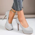 Close-up of sparkling silver glitter platform high heels with stiletto heel worn by model - Silver