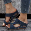 Close-up of navy blue wedge sandals with floral accents and laser-cut details. - 36 / Dark Blue