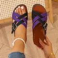 Close-up of purple and black criss-cross strap sandals worn on foot and held by hand - 36 / Purple