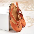 Close-up of orange suede sandals featuring elegant hollow-out flower patterns and cork soles. - 34 / Yellow