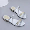 Detalle de sandalias plateadas de dos posiciones con tiras de pedrería y tacón bajo cómodo - 43 / Plateado