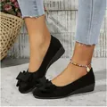 Close-up view of elegant black suede wedge pumps featuring a stylish bow detail on the toe - 36 / Black Flower