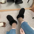 Cozy black fur-lined loafers worn with jeans on a stylish rug - 35 / Black