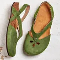 Close-up detail of green suede flat sandals with hollow-out flower design and cork sole - 34 / Green