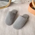 Detailed view of grey faux fur slippers on a textured rug for cozy indoor wear - 36-37 / Gray