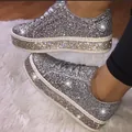 Detailed view of sparkling silver rhinestone platform sneakers worn on a white fur rug - 35 / Silver