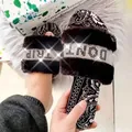 Dettaglio di ciabatte in ecopelliccia nera con cinturini decorati in strass e stampa paisley - 35 / Nero