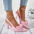 Detailaufnahme von rosa Satin-Slingback-Heels mit eleganter Schleife und spitzer Zehenpartie - Rosa