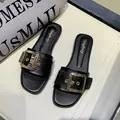 Stylish black flat slides for women featuring a decorative gold square buckle detail - 35 / Black