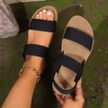 Detail view of women's black elastic strap sports sandals featuring a comfortable tan soft sole - 36 / Black