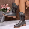 Close-up detail of grey mid-calf boots with brown laces and silver stud accents - 35 / Gray