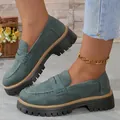 Détail de mocassins en daim bleu sarcelle rétro à semelle plateforme épaisse sur un modèle. - Vert Foncé