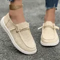 Macro view of beige canvas women's loafers showing natural fabric texture and stitching - Apricot