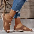 Close-up of brown women's wedge sandals with perforated hollow-out design - Tan