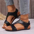 Gedetailleerd zicht op zwarte sleehak sandalen met klittenband gedragen door model. - 35 / Zwart