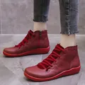 Close-up view of stylish red women's casual ankle boots with side zippers on model - 35 / Red