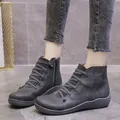 Detail showing the grey casual ankle boots with cross-lace design and side zipper. - Gray