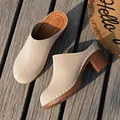 Elegant beige chunky heel closed-toe mules shown on a rustic outdoor wooden deck - 36 / Beige