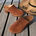 Elegant brown suede mule slippers with chunky heels on a sunny wooden boardwalk - 36 / Brown