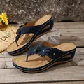 Detailed view of navy blue wedge thong sandals with three decorative leather flowers. - Dark Blue